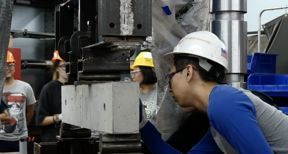 students marking measurements on concrete beam